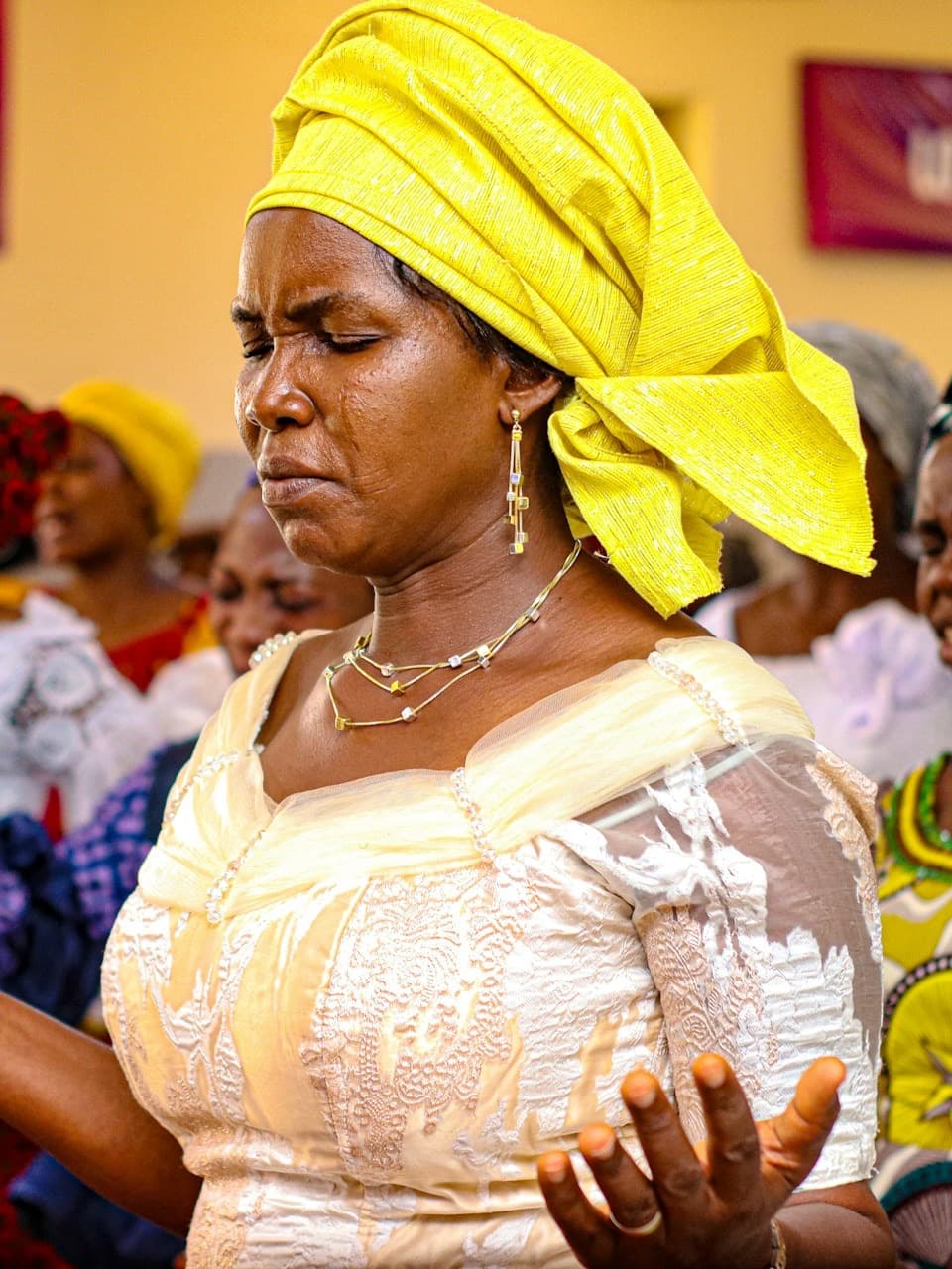 Women praying together in worship (stock photograph by Prince Kwembe)